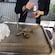 A pair of hands holding a freshly opened oyster and a shucking knife